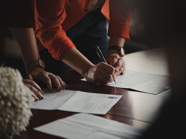 Two people signing a lease for a commercial property.