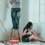 Couple painting home to improve your investment property's ROI.