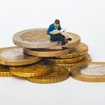 An image of a figurine sitting on a pile of coins.