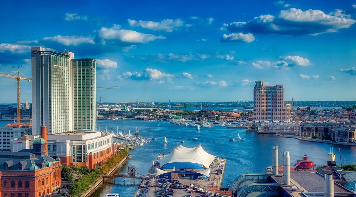 A distant photo of Baltimore’s harbor under a cloudy skyline.