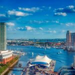 A distant photo of Baltimore’s harbor under a cloudy skyline.