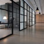 A photo of an office hallway between glass doors used to illustrate the importance of crisis-proofing commercial real estate.