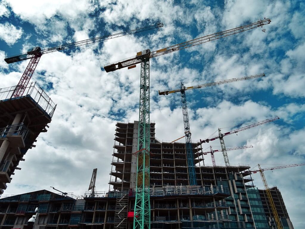 Green and yellow cranes on construction sites.