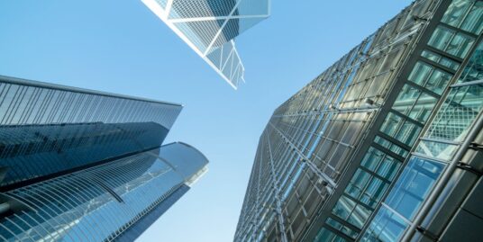 Three commercial buildings under the blue sky.