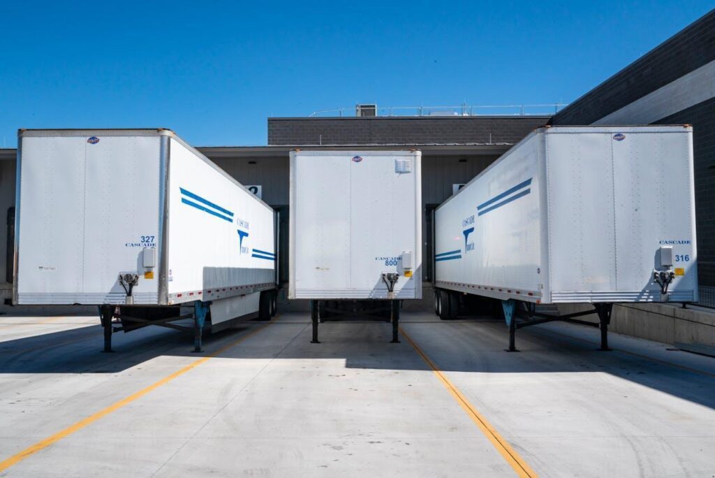 Three white enclosed trailers.